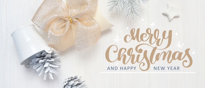 Mockup Christmas white tree, beige bow and cones with calligraphy text Merry Christmas. Flat lay on a white wooden background. Top view